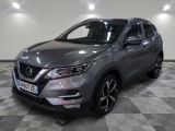 a grey nissan qx - v parked on a checkered floor