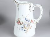 a white pitcher with a floral design on it