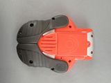 an orange and gray plastic object on a gray surface