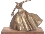 bronze sculpture of a woman in a flowing dress on a wooden base