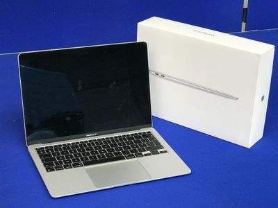 un ordinateur portable MacBook Pro d'Apple posé à côté d'une boîte blanche