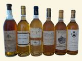 plusieurs bouteilles de vin sont alignées sur une surface blanche