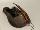 a hat with a feather on it sitting on a sink