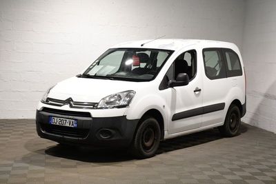 La petite camionnette blanche est garée dans une grande pièce.