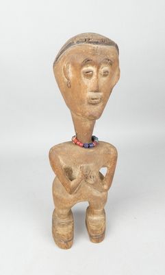 a small wooden figurine of a man with a hat on his head