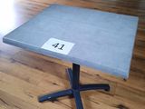 une petite table sur laquelle est inscrit un chiffre, posée sur un parquet
