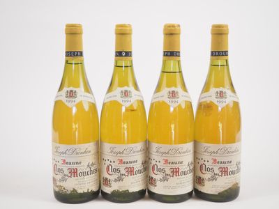 quatre bouteilles de vin sont alignées sur une surface blanche