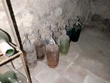 de nombreuses bouteilles en verre alignées sur une étagère dans une pièce