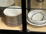 many plates and bowls on display in a glass case