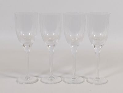quatre verres à vin vides alignés sur une surface blanche