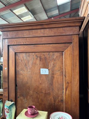 une armoire en bois sur laquelle est posé un chapeau rose