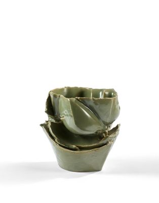 un petit bol vert avec une fleur à l'intérieur