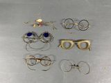 several pairs of glasses are sitting on a metal surface