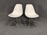 pair of white eames side chairs with chrome legs