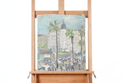 un tableau posé sur un chevalet, avec en arrière-plan un tableau représentant un paysage urbain