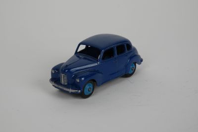 une petite voiture bleue posée sur une surface blanche