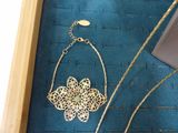 a picture of a necklace with a flower on it