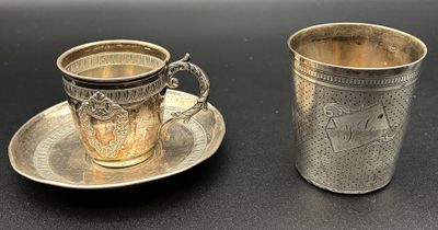 une tasse et une soucoupe argentées posées sur une table noire