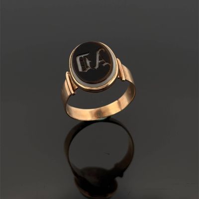 une image d'une bague en or avec une pierre noire au centre