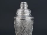 a silver plated cocktail shaker on a black background