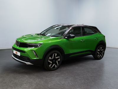 un SUV vert garé dans une pièce aux murs blancs
