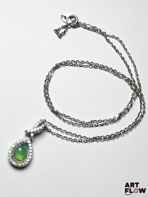 chaîne en argent avec un pendentif vert en forme de larme sur fond blanc