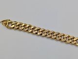 a close up of a gold chain bracelet on a white surface