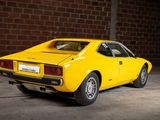 a yellow car parked in a garage with a brick wall in the background