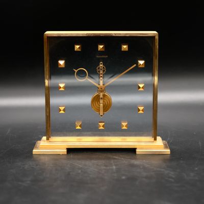 an image of a gold clock sitting on top of a table