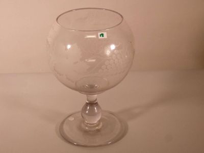 un verre sur lequel est collé un autocollant vert, posé sur une table
