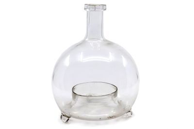 une bouteille en verre transparent avec un socle en métal