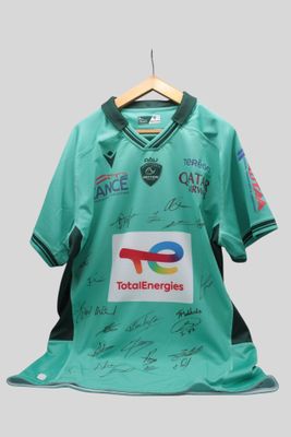 un gros plan sur un maillot vert portant des signatures