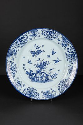 blue and white plate with birds and flowers on it
