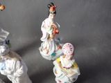 three figurines of asian women sitting on a table