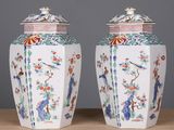une paire de vases chinois posés sur une table en bois, sur fond gris