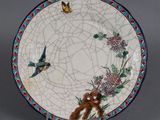 une assiette ornée d'un motif représentant un oiseau et une fleur