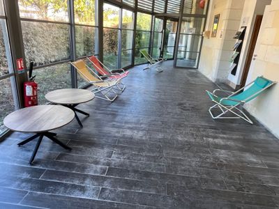 several lawn chairs are lined up in a row on a porch