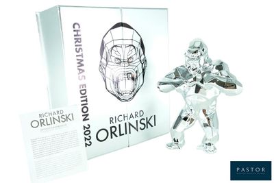 a silver figurine of a man holding a knife in front of a box