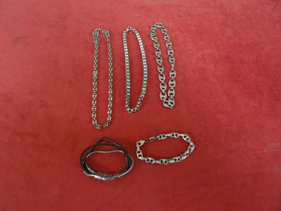 three pairs of scissors and a chain on a red surface