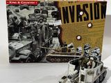des jouets sont posés sur une table à côté d'une boîte sur laquelle figure l'image d'un véhicule militaire