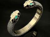 un gros plan de la tête d'un serpent sur un bracelet en or