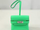 un petit sac à main vert posé sur une table blanche