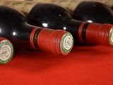 several bottles of wine are lined up on a red table