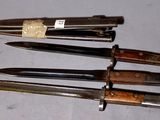 several knives are lined up on a table with a tag on them