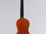 a guitar hanging from a string on a white wall