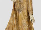 wooden statue of a standing buddha with a raised hand