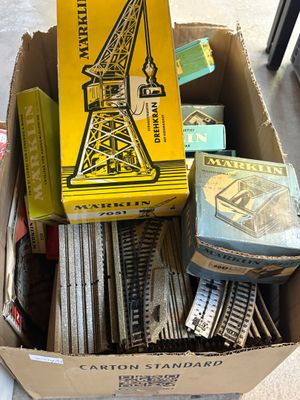 une boîte en carton remplie de rails de train et une boîte contenant d'autres rails de train