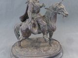 statue en bronze représentant un homme à cheval avec un chien sur le dos