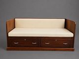 a wooden day bed with two drawers and a white cushion