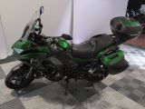 a green motorcycle that is parked on a checkered floor
